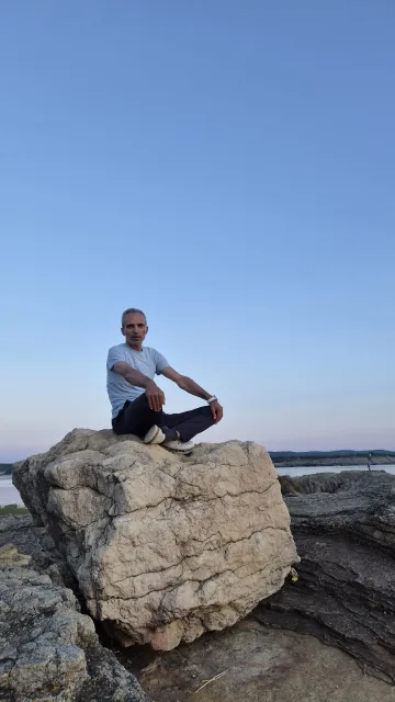 Galip Arduç'un Kocaeli'nin Kandıra ilçesine bağlı Kefken'deki Pembe Kayalıklar üzerinde, deniz manzarası ve mavi gökyüzü eşliğinde otururken çekilmiş fotoğrafı.
