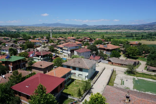 Galip Arduç’un memleketi Çalkara Köyü’nü; evleri, yeşil arazileri, cami minaresi ve çevresindeki dağlarla birlikte gösteren geniş açı manzara fotoğrafı.