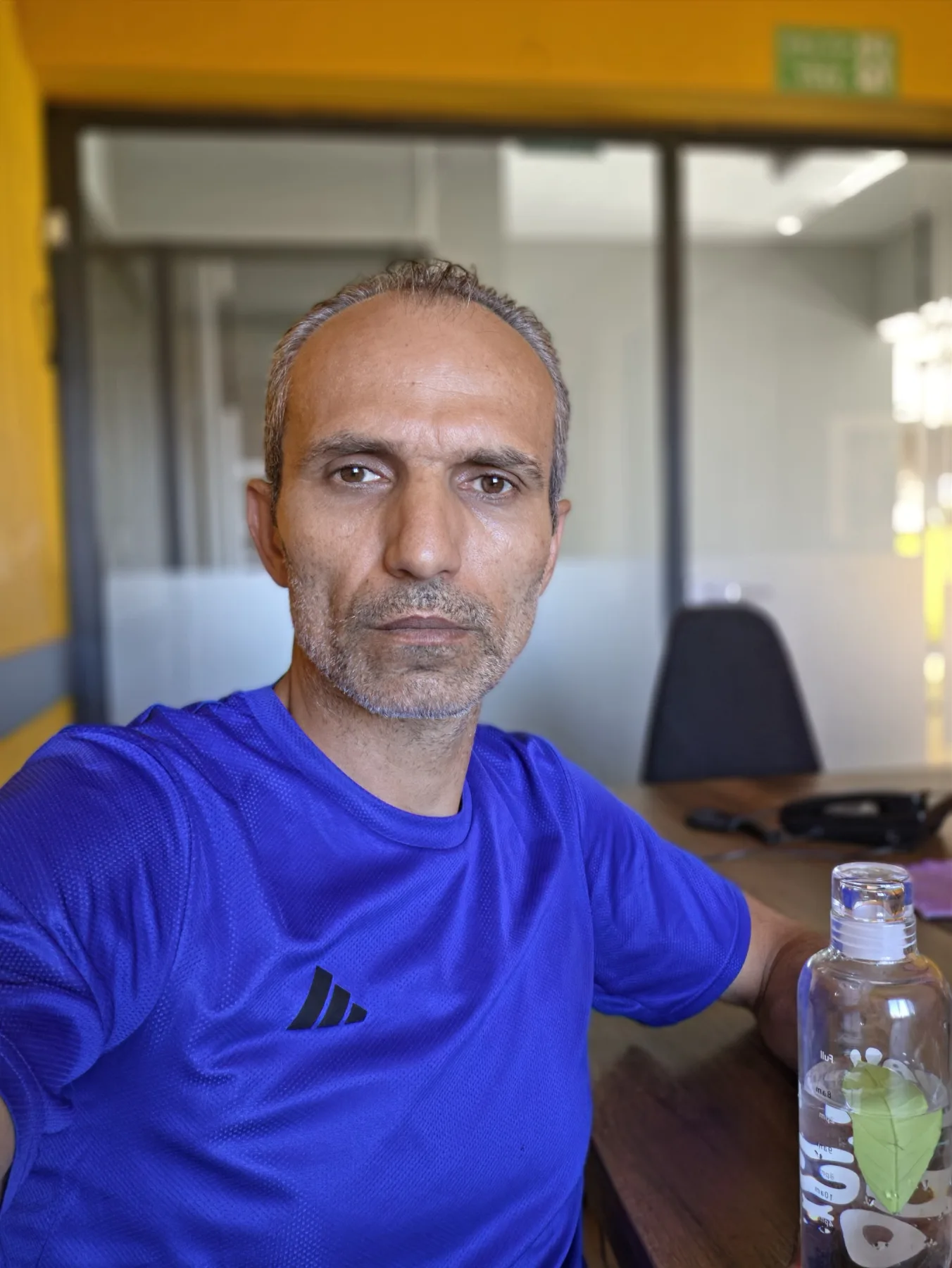 Galip Arduç’un iş albümünden, toplantı masasının yanında mavi tişörtlü bir kişinin yer aldığı ofis karesi.